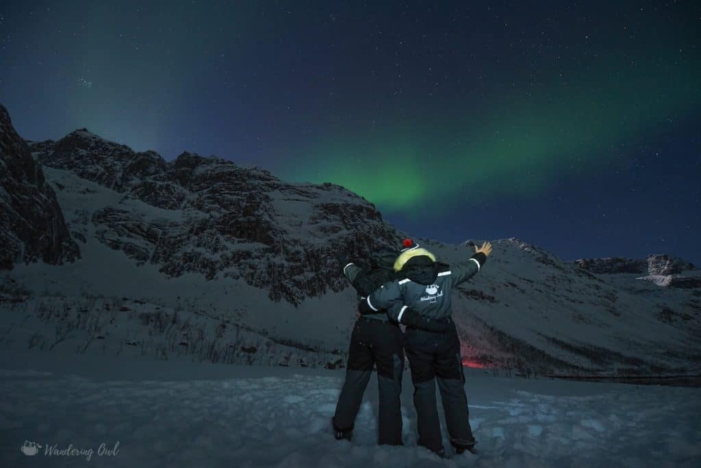 Vue de 2 personnes de dos avec une aurore boréale à Tromso